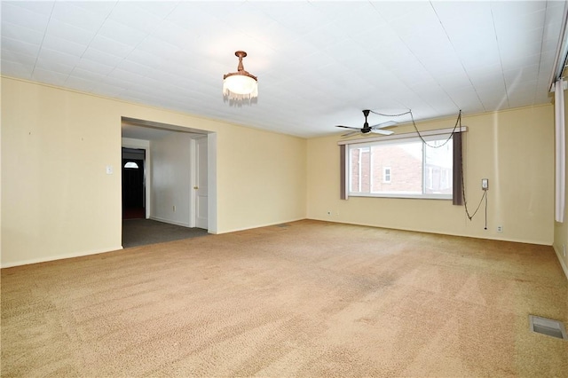 carpeted spare room featuring ceiling fan