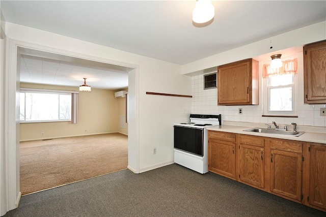 kitchen with electric stove, sink, backsplash, a wall unit AC, and dark carpet