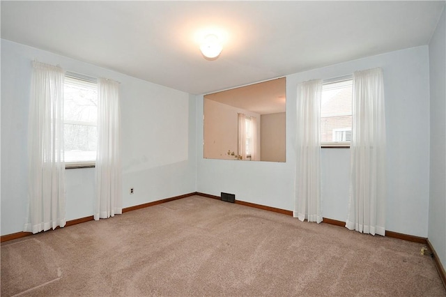 carpeted spare room with a wealth of natural light