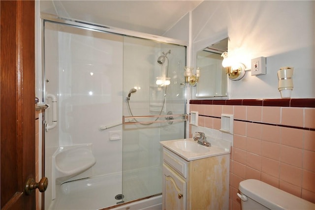 bathroom featuring tile walls, vanity, a shower with door, and toilet