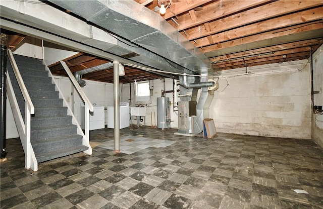 basement with heating unit, sink, gas water heater, and washing machine and dryer