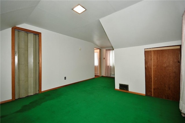 bonus room with lofted ceiling and dark carpet