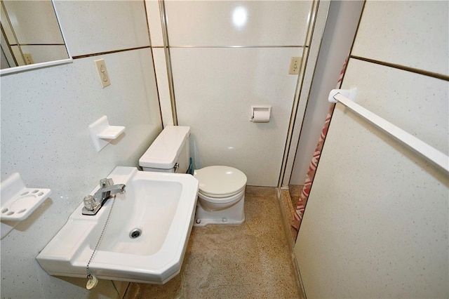 bathroom featuring walk in shower, toilet, and sink