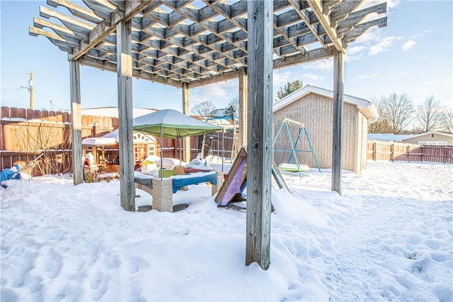 yard covered in snow with a storage unit