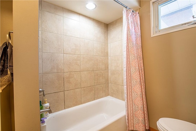 bathroom featuring toilet and shower / tub combo with curtain