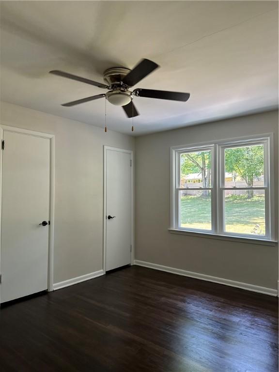 empty room featuring dark hardwood / wood-style floors and ceiling fan