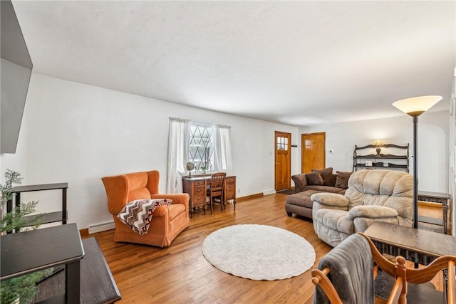 living room featuring baseboard heating and hardwood / wood-style flooring