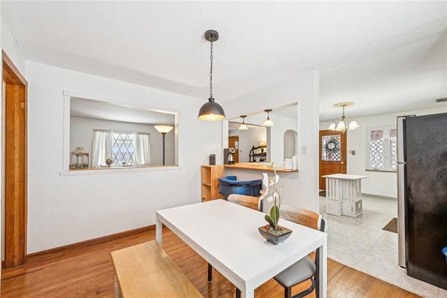 dining space featuring light hardwood / wood-style flooring and an inviting chandelier