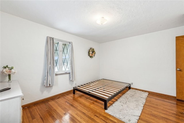 bedroom featuring wood-type flooring and a textured ceiling