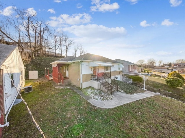 back of house featuring a yard and central AC