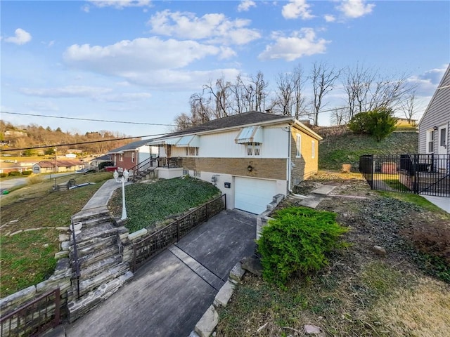 view of front of house with driveway, a garage, and fence