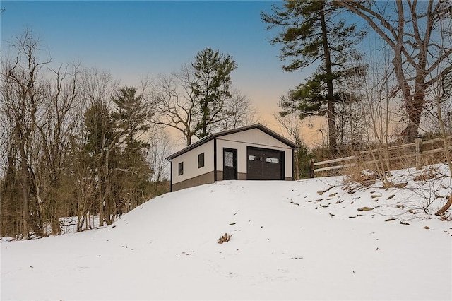 snow covered structure featuring a garage