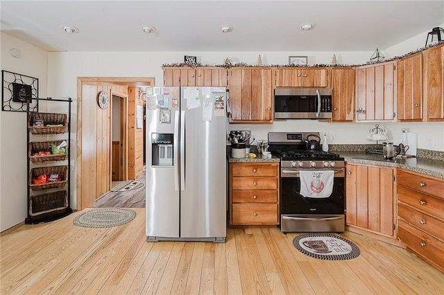 kitchen with stainless steel appliances and light hardwood / wood-style flooring