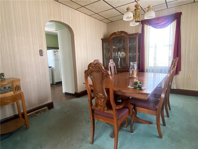 carpeted dining room with a chandelier