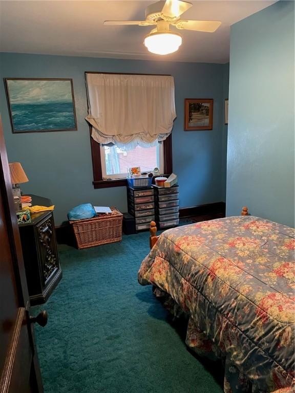 bedroom featuring ceiling fan and dark carpet