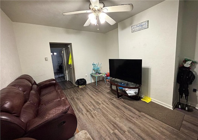 living room with ceiling fan and dark hardwood / wood-style flooring