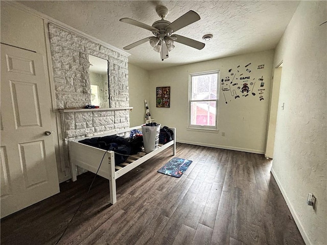 unfurnished bedroom with ceiling fan, a textured ceiling, and dark wood-type flooring