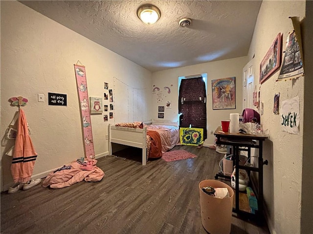 bedroom featuring a textured ceiling and dark wood-type flooring