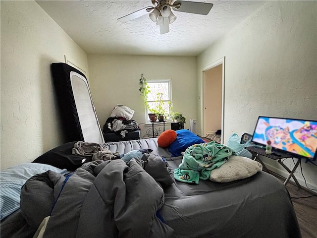 bedroom featuring carpet flooring, ceiling fan, and a textured ceiling