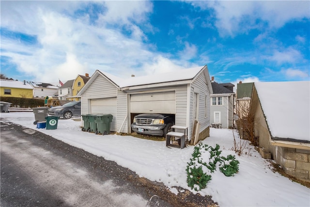 snow covered property with a garage