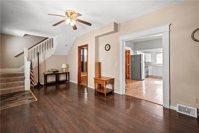 living room featuring visible vents, a ceiling fan, hardwood / wood-style flooring, baseboards, and stairs