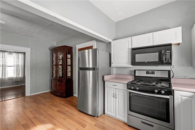 kitchen featuring light countertops, light wood-style flooring, white cabinets, and stainless steel appliances