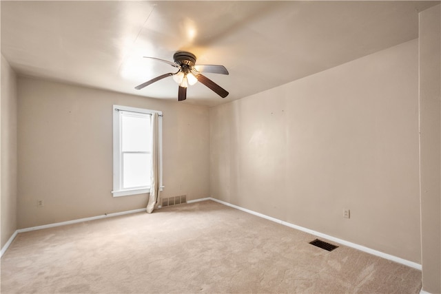 unfurnished room featuring light carpet, visible vents, baseboards, and ceiling fan