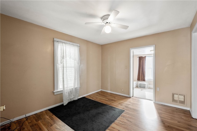 unfurnished room featuring wood finished floors, visible vents, and a wealth of natural light