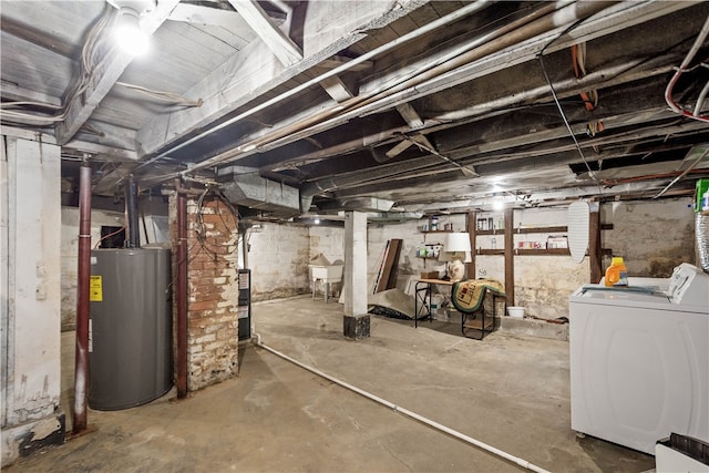 unfinished below grade area with a sink, washing machine and dryer, and water heater