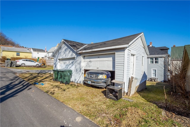 view of side of home featuring a lawn and a garage