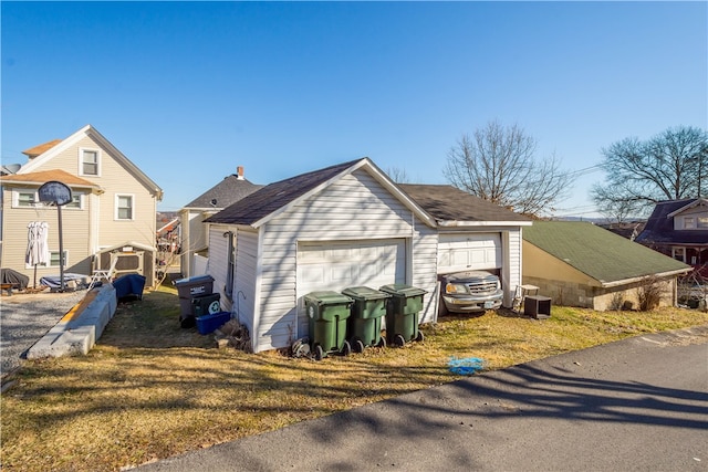 view of home's exterior with an outdoor structure, central AC unit, and a detached garage