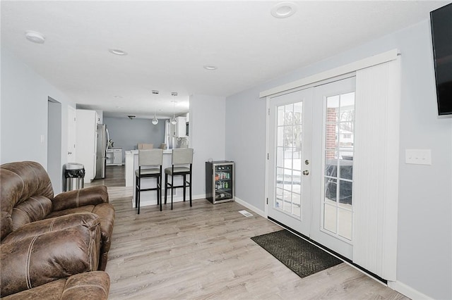 interior space featuring light hardwood / wood-style floors, wine cooler, and french doors