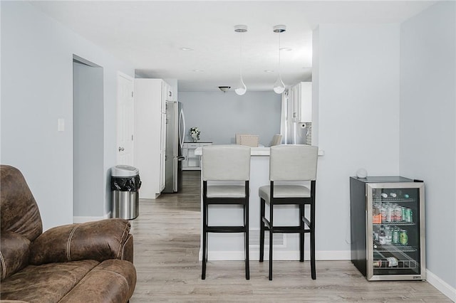 dining space featuring light hardwood / wood-style floors and wine cooler