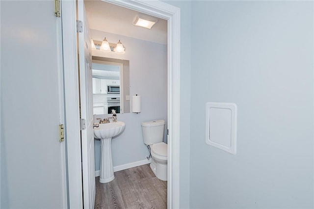 bathroom with hardwood / wood-style floors and toilet