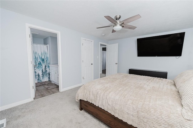 carpeted bedroom featuring ensuite bath and ceiling fan