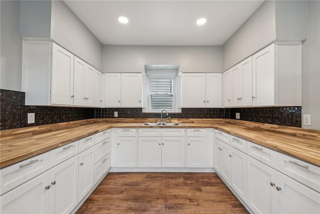 kitchen with white cabinetry, sink, dark wood-type flooring, and wooden counters