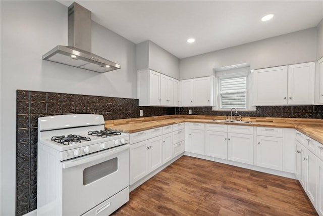 kitchen featuring white cabinetry, wall chimney range hood, and white range with gas cooktop