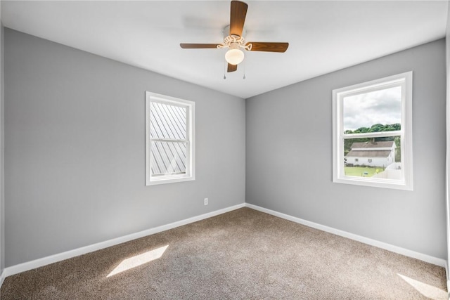 carpeted spare room featuring ceiling fan