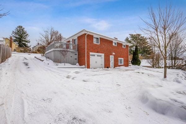 view of snowy exterior featuring a balcony and a deck