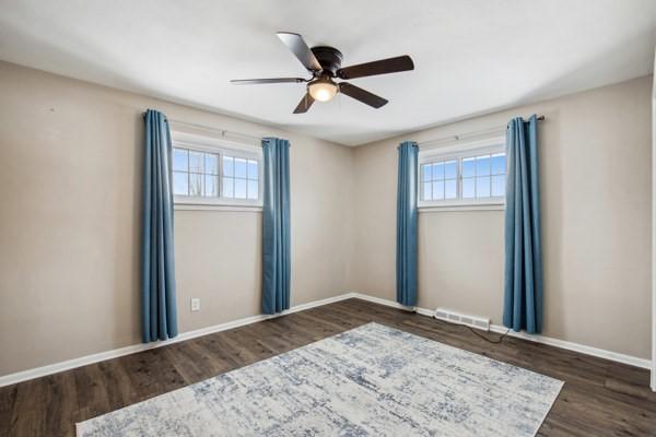 spare room featuring ceiling fan and dark wood-type flooring