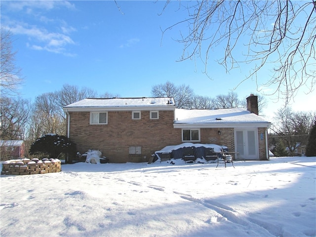 snow covered property with french doors