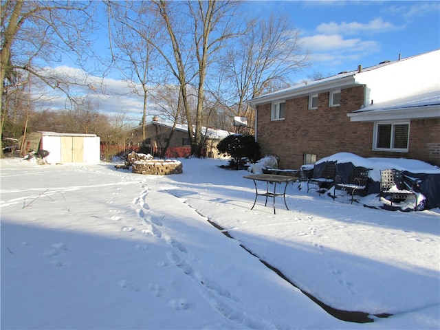 yard covered in snow featuring a storage unit