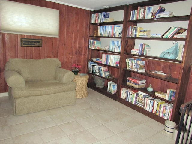 sitting room featuring light tile patterned flooring and wood walls