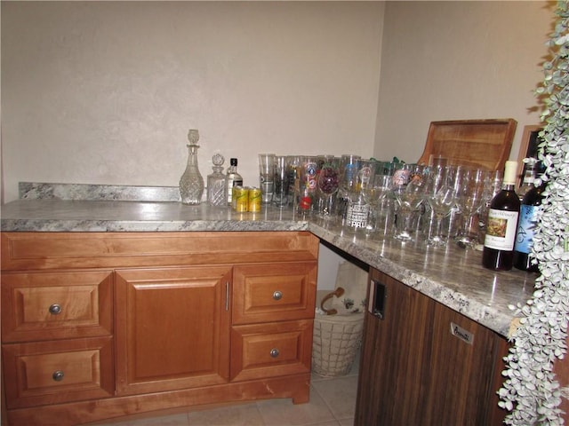 kitchen featuring light tile patterned floors and light stone countertops