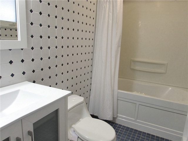 full bathroom with toilet, vanity, tile patterned flooring, tile walls, and shower / bath combo with shower curtain