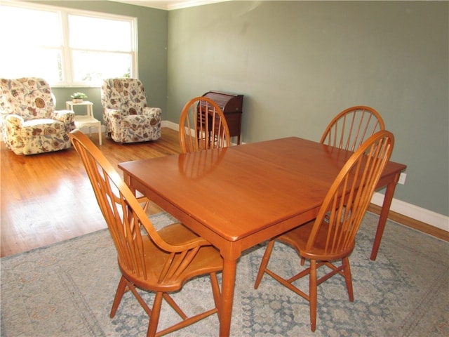 dining area featuring crown molding and hardwood / wood-style flooring