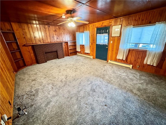 unfurnished living room with carpet, wooden walls, a baseboard heating unit, and wood ceiling