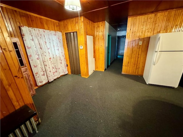 interior space featuring white refrigerator and wooden walls