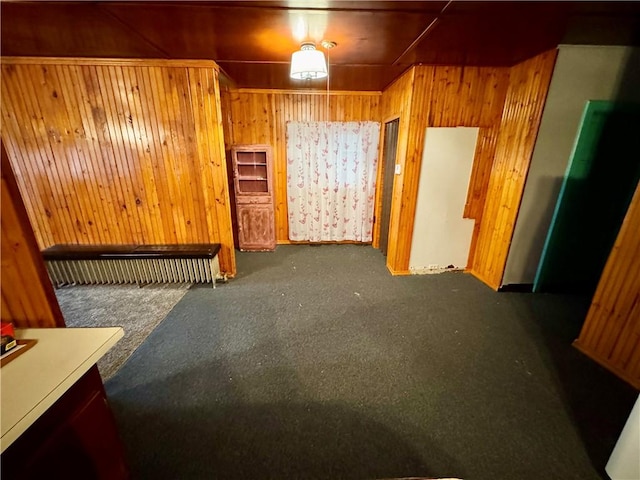 carpeted empty room with wood walls