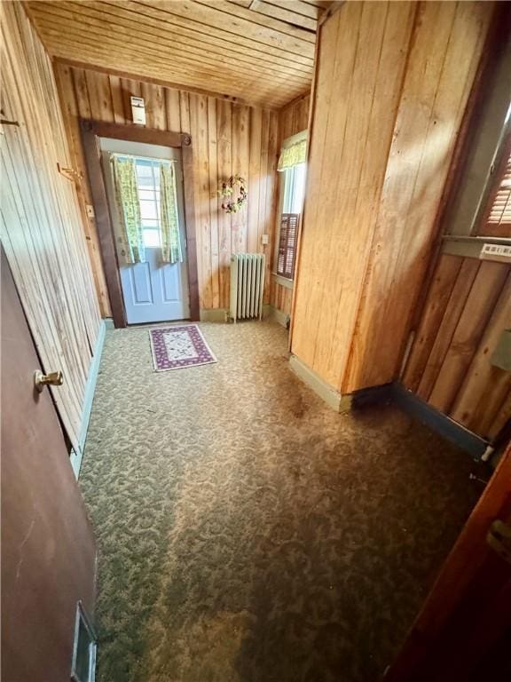 doorway to outside with radiator and wood ceiling